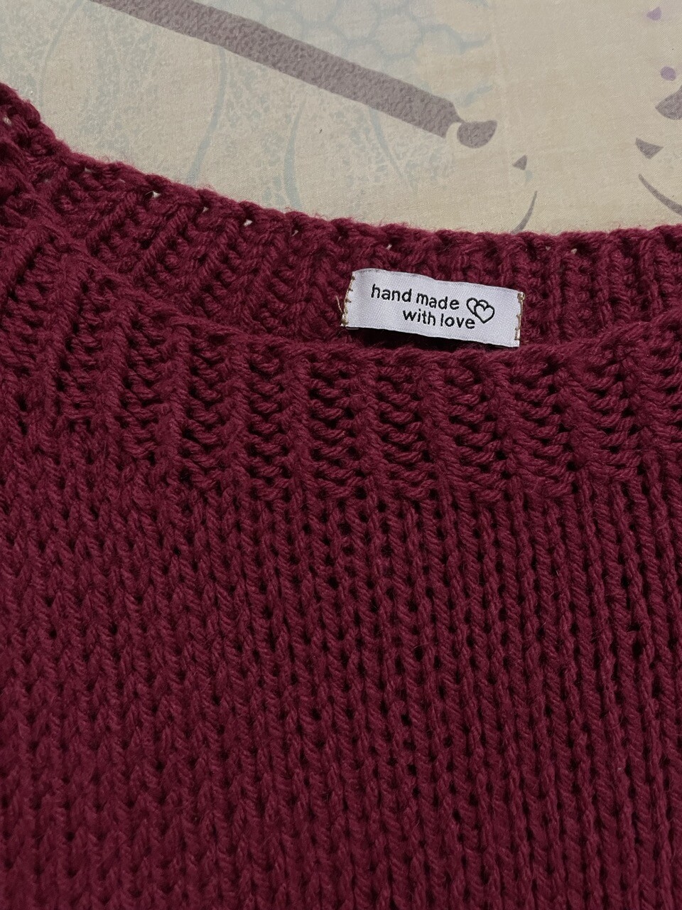 Clothing label with the words handmade with love sewn on the collar of the sweater