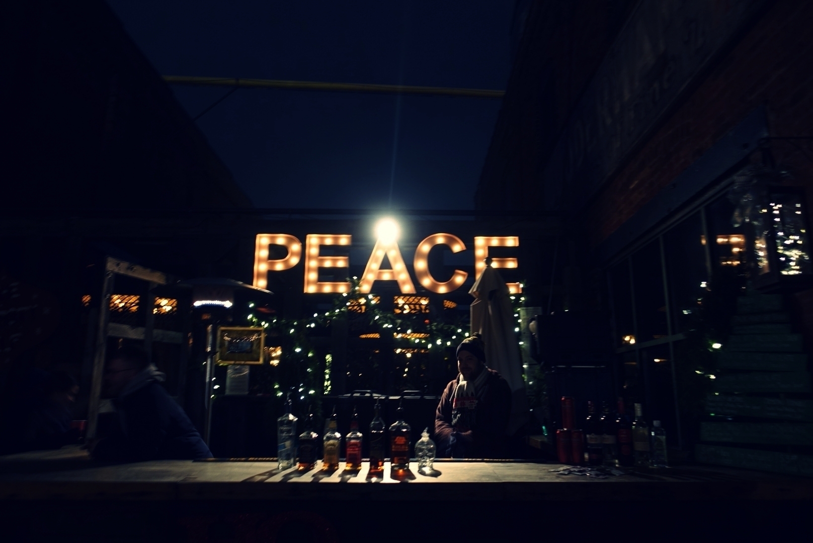 The letters P E A C E all lit up in a Christmas market stall