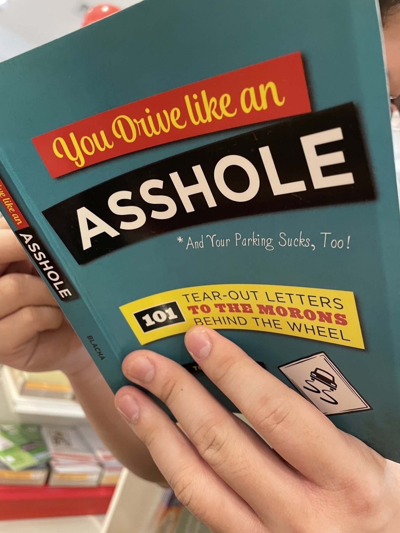 Cover of a random book in a store reads&10;"You Drive like an Asshole" &10;among other things 