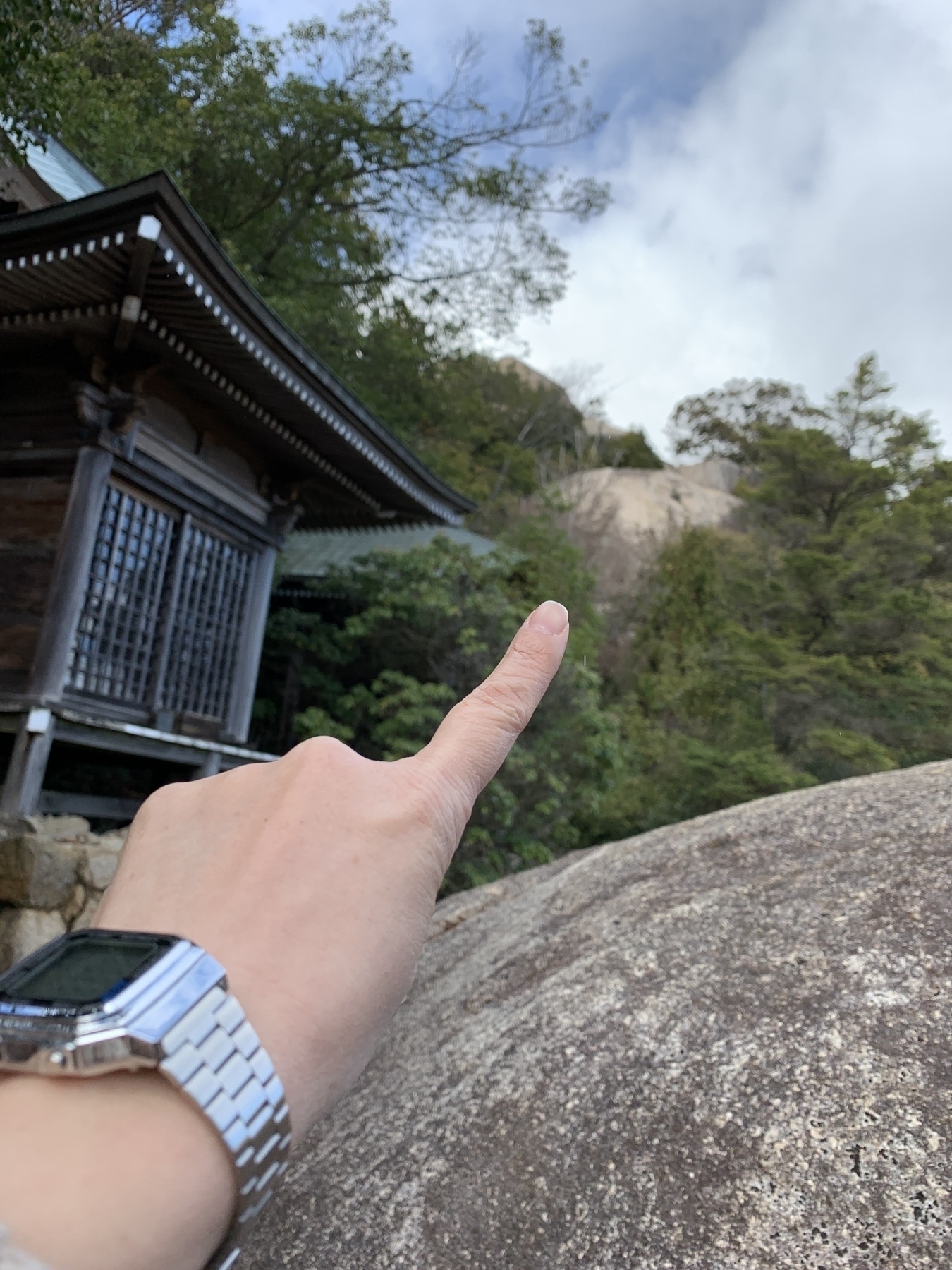 Finger pointing to the top of the mountain hiking trail